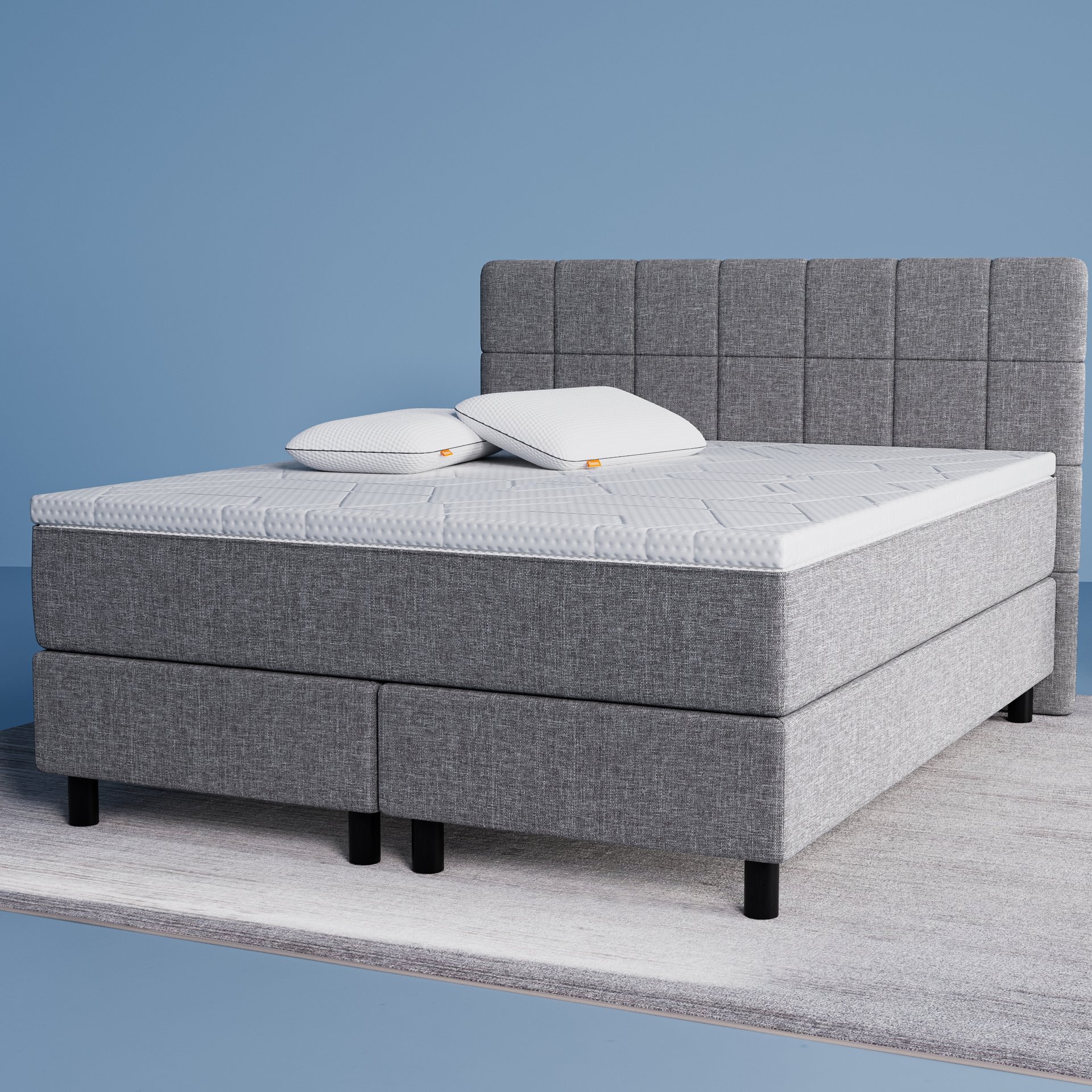 Das original Boxspringbett mit 2 Polster und einer Matratzenauflage in einem Zimmer mit blauen Wänden.
