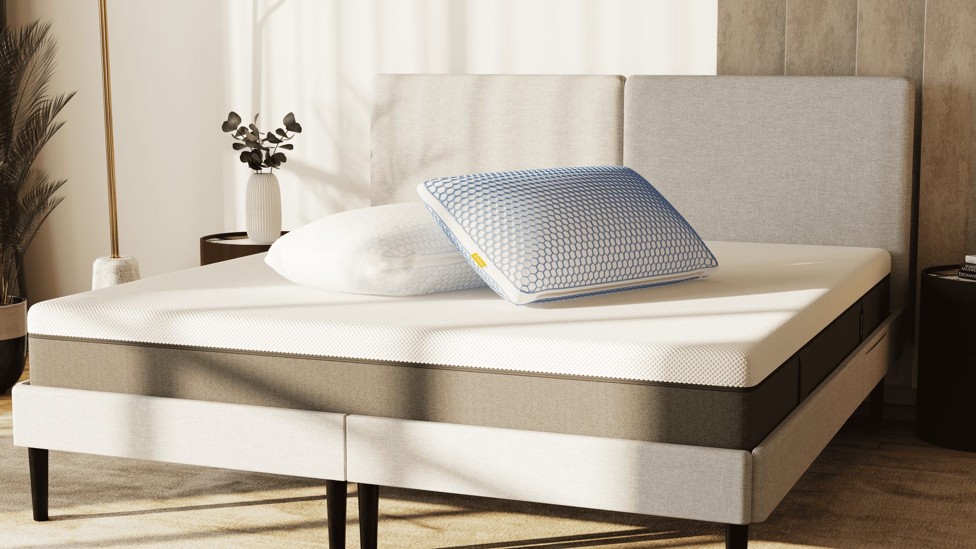 Zwei ergonomische Kissen auf einem modernen Boxspringbett mit Schaumstoffmatratze in einem sonnendurchfluteten Schlafzimmer.
