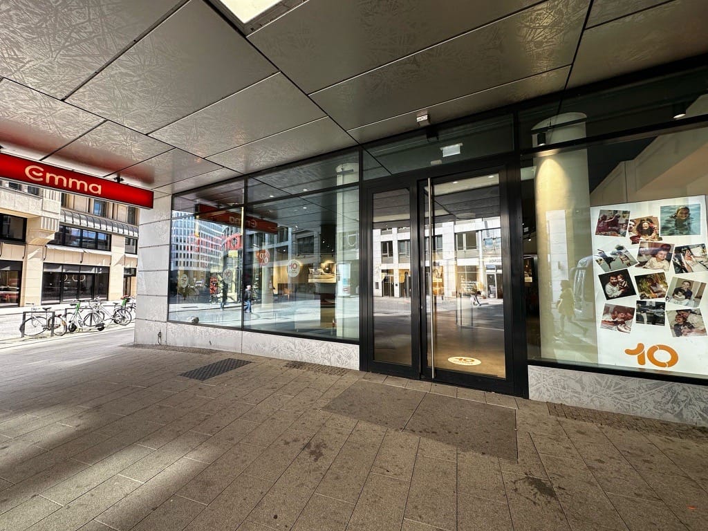 Emma Store Hamburg, großer Glasfront, rotes Emma-Logo, Werbeplakate sichtbar.