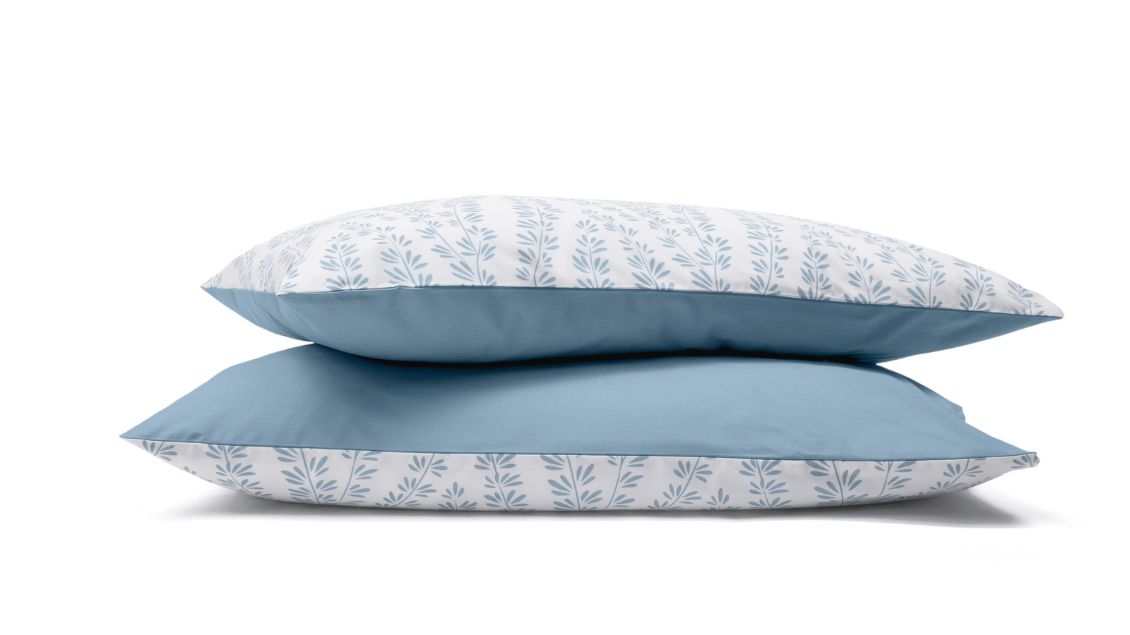 Due federe con motivo floreale azzurro e bianco impilate su sfondo bianco.