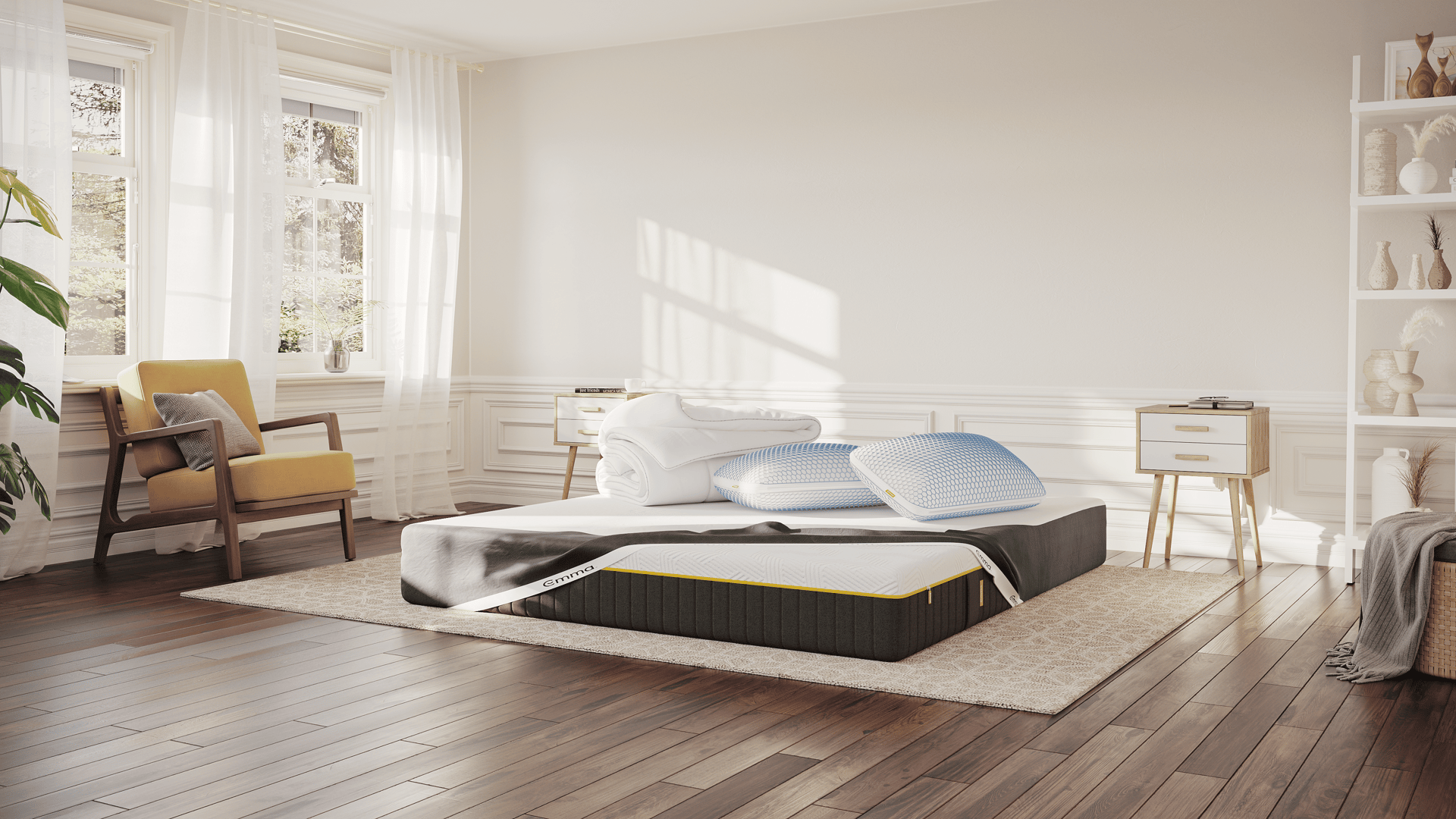 Emma Super Deal in een lichte, moderne slaapkamer: Emma AirGrid Matras met witte en grijze hoes, opgerold Emma 4-Seizoenen Dekbed en twee Emma AirGrid WolkenKussens met blauwe accenten bovenop het matras.