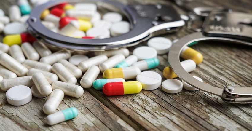 handcuffs and pills on wood RETINA.jpg handcuffs and pills on wood RETINA.jpg