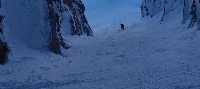 Skifahrer in der Ferne zwischen Bergen in Albanien.