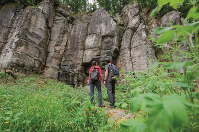 Zwei Wanderer begutachten eine beeindruckende Felswand