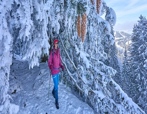 Eine Person beim Wandern in einer verschneiten Winterlandschaft in Balderschwang.