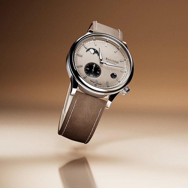 Ba111od Chapter 8, Uhr mit Mondphase und weißem Zifferblatt vor braunem Hintergrund