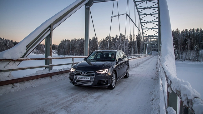 Auto auf Brücke bei Schnee im Winter.