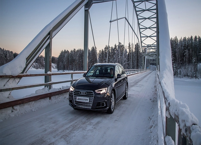 Auto auf Brücke bei Schnee im Winter.