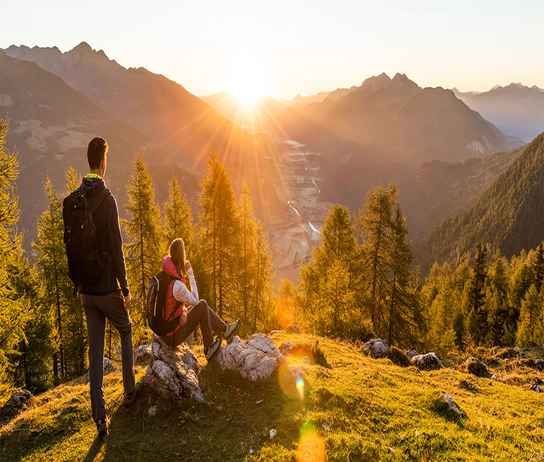 Ausblick auf Bergkulisse mit Sonne am Horizont.