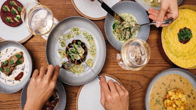 Mehrere kulinarische Gerichte auf einem Esstisch im „Tian Bistro am Berg“.