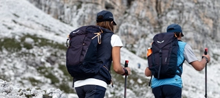 Zwei Wanderer während des Aufstiegs mit Rucksäcken im felsigen Gelände. 