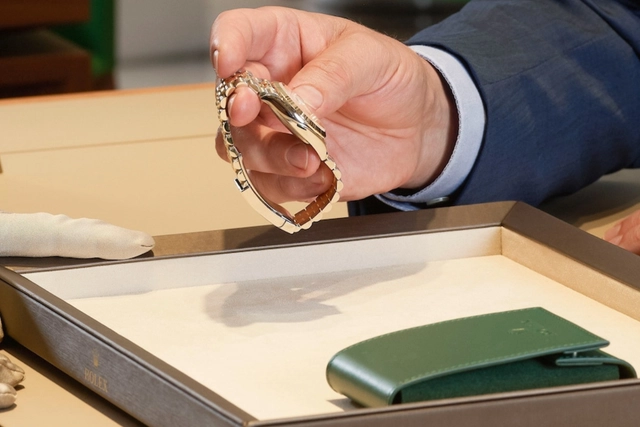 Rolex Secondhand Mann hält Rolexuhr
