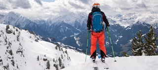 Eine Person auf Ski mit Blick auf die verschneite Bergkulisse des Zillertals.