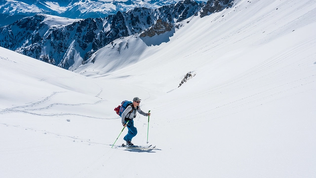 Skitourengeher vor schneebedeckter Bergkulisse in Tirol.
