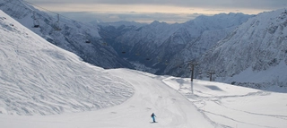 Skifahrer auf Piste vor weitem Bergpanorama im Aostatal.