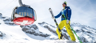 Person mit Ski vor Gondelbahn in Engelberg-Titlis.