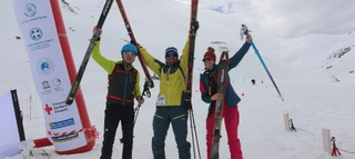 Drei Personen mit Skitour-Equipment vor schneebedeckten Bergen auf Kreta.