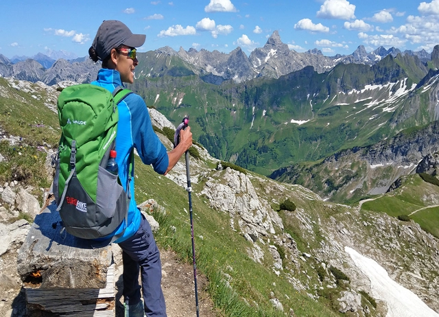 Eine Person mit Panoramaaussicht auf Bergkulisse in den Allgäuer Alpen.