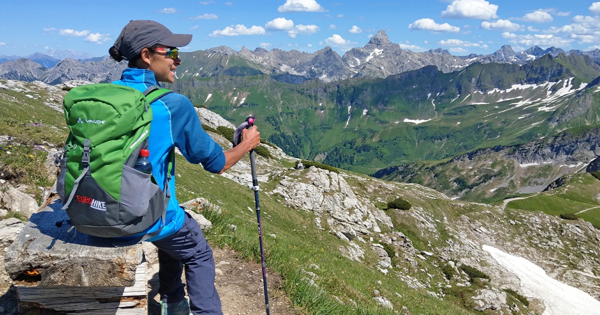 Eine Person mit Panoramaaussicht auf Bergkulisse in den Allgäuer Alpen.