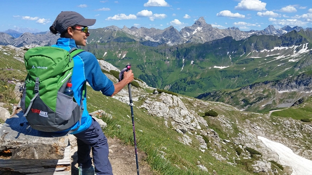 Eine Person mit Panoramaaussicht auf Bergkulisse in den Allgäuer Alpen.
