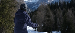Skifahrer mit Blick in Richtung Berge und Bäume in Südtirol.