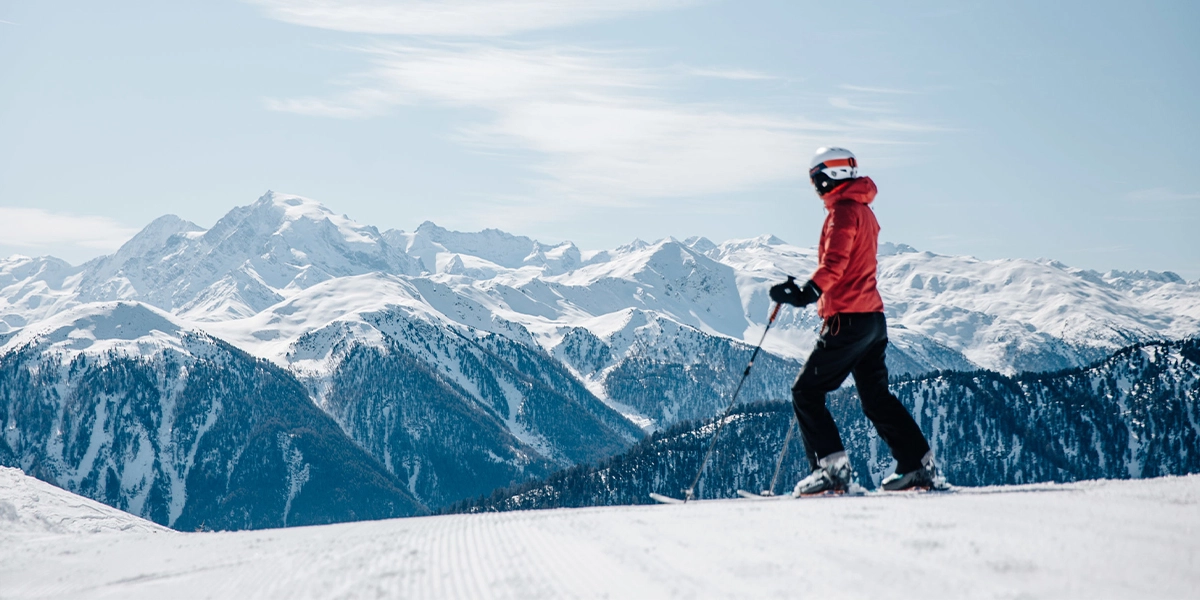 Person auf Ski vor verschneitem Bergpanorama in der Zwei Länder Skiarena.