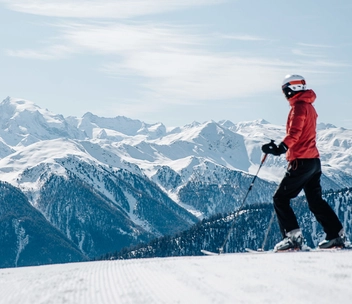 Person auf Ski vor verschneitem Bergpanorama in der Zwei Länder Skiarena.