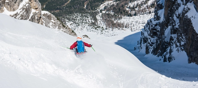 Aufnahme eines Skifahrers zwischen Bergen in Richtung Tal in Tirol.