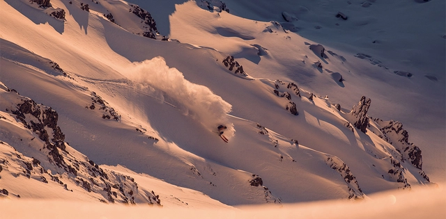 Freerider bei Abfahrt im Tiefschnee.