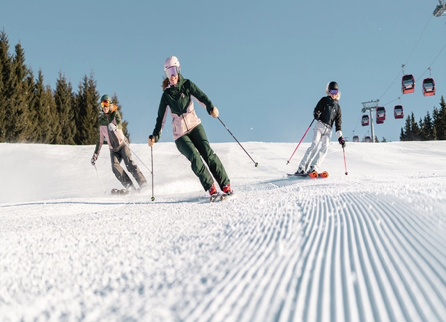 Drei Skifahrer auf der Piste.