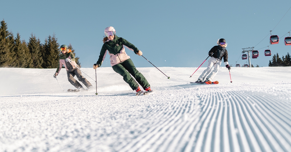 Drei Skifahrer auf der Piste.