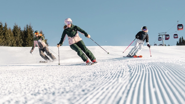 Drei Skifahrer auf der Piste.