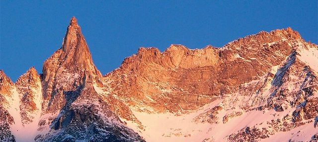 Berge mit Schnee vor tiefblauem Himmel.