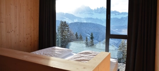 Ausblick aus einem Hotelzimmer auf verschneite Berglandschaft in Italien.