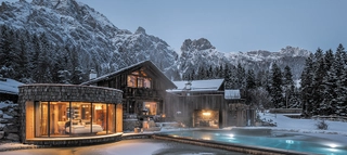Villa Wossa bei Leogang im Salzburger Land vor verschneiter Bergkulisse.