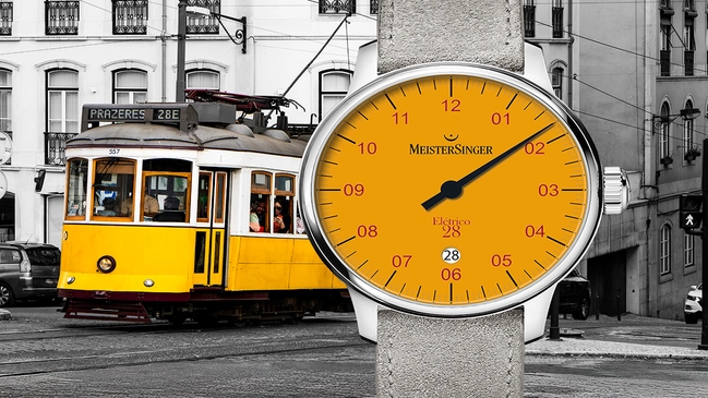 Meistersinger Eletrico 28 mit Tram im Hintergrund