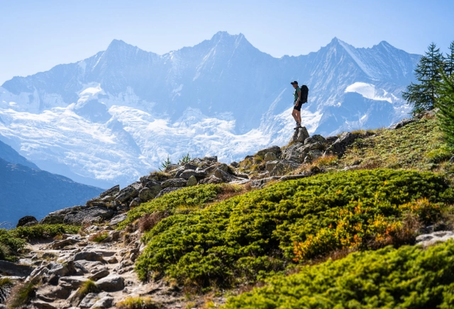1.png Beeindruckendes Bergpanorama im Hintergrund mit einem einsamen Wanderer auf einem Bergkamm im Vordergrund