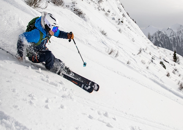 Skifahrer bei Abfahrt mit Tourenski.