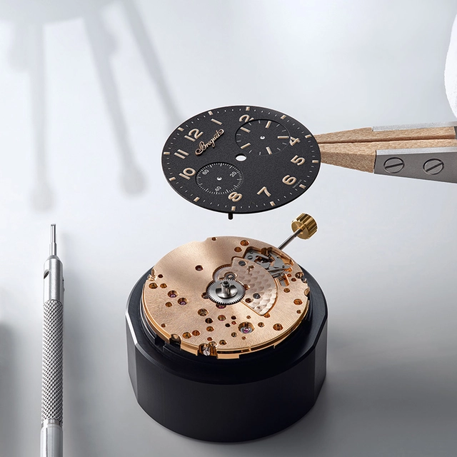 Breguet Type XX Chronograph 2075 mit Zifferblatt aus schwarz eloxiertem Aluminium Type XX Chronograph 2075, Zifferblatt Detail mit Pinzette über Uhrwerk gehalten