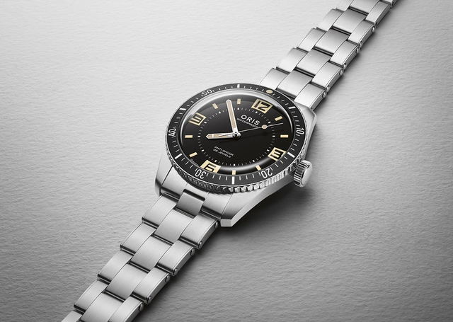 Oris Divers Sixty-Five 60th Anniversary Edition, Edelstahluhr vor grauem Hintergrund