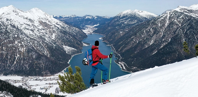 Skitourengeher beim Aufstieg mit Blick auf den Achensee