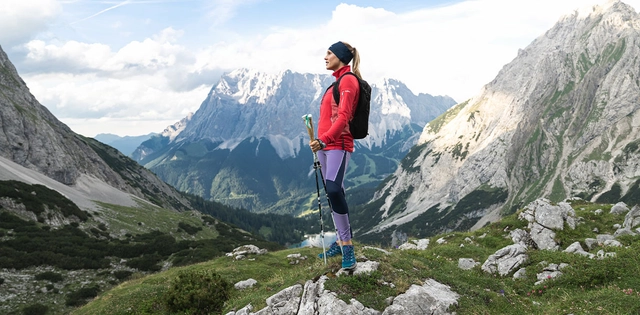 Wanderin stehend mit Blick in die Ferne auf das Bergpanorama.