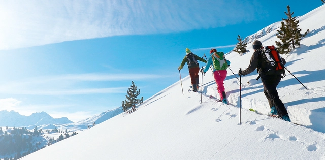 Skitourengeher während des Aufstiegs im Schnee bei schönem Wetter im Val Müstair.