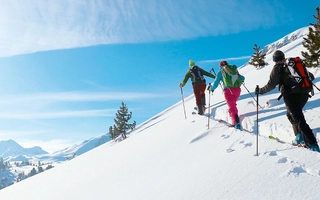 Skitourengeher während des Aufstiegs im Schnee bei schönem Wetter im Val Müstair.