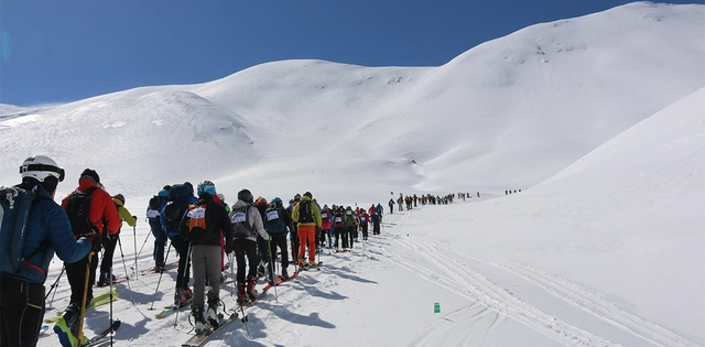 Zahlreiche Skitourengeher vor verschneiter Bergkulisse auf Kreta.