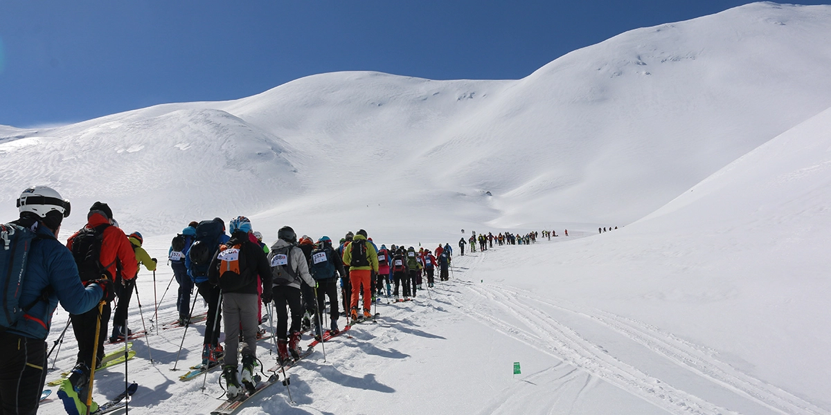 Zahlreiche Skitourengeher vor verschneiter Bergkulisse auf Kreta.