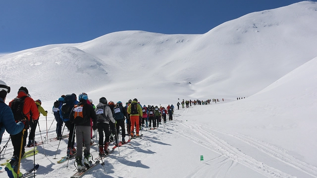 Zahlreiche Skitourengeher vor verschneiter Bergkulisse auf Kreta.