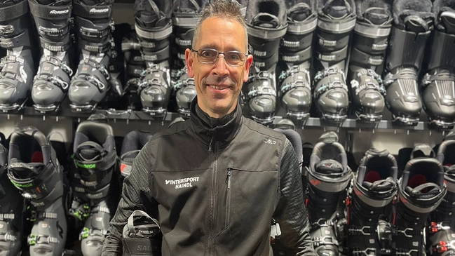 Bootfitter Matthias Schmidt vor Skischuhwand.