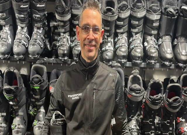 Bootfitter Matthias Schmidt vor Skischuhwand.