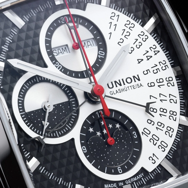 Beim Averin Chronograph von Union Glashütte wird die Datumsanzeige über einen unkonventionellen Dreifach-Zeiger realisiert. Mit seinen unterschiedlich langen Armen steuert er die Datumsziffern in drei Ebenen an, die im silberfarbenen Teil des Zifferblattes untergebracht sind.